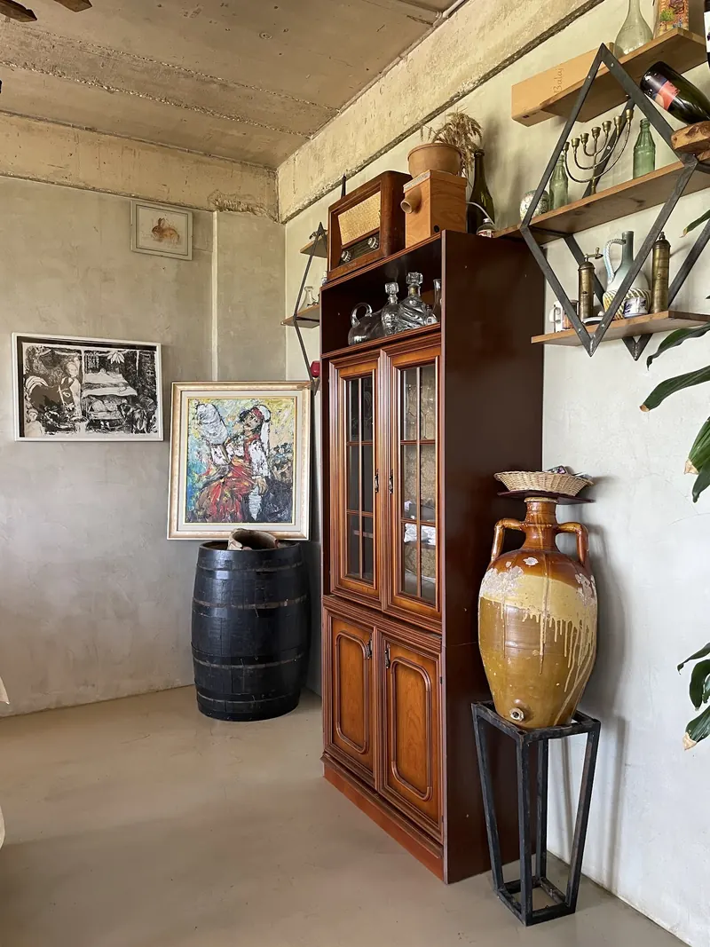 A clay amphora next to a wooden cabinet and a barrel