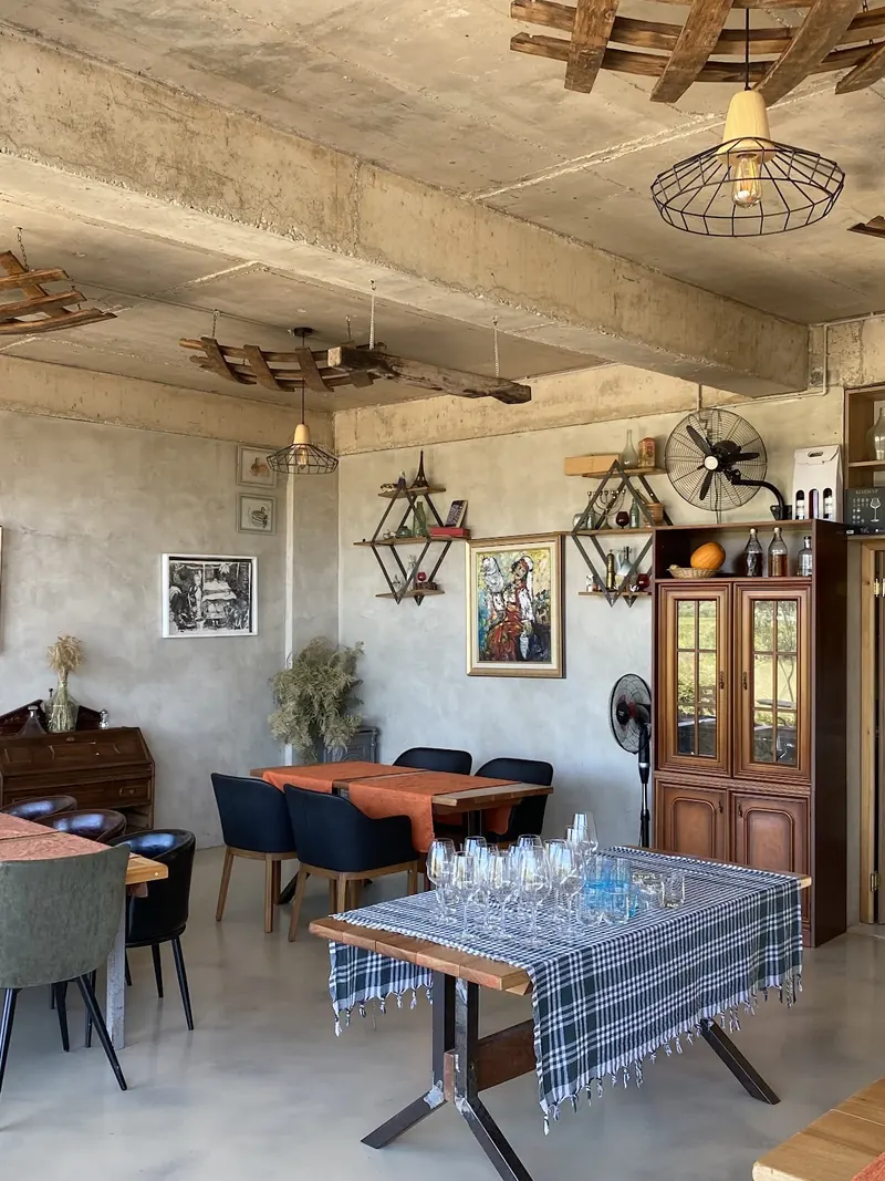 Dining hall with paintings, wine racks and checked tablecloths